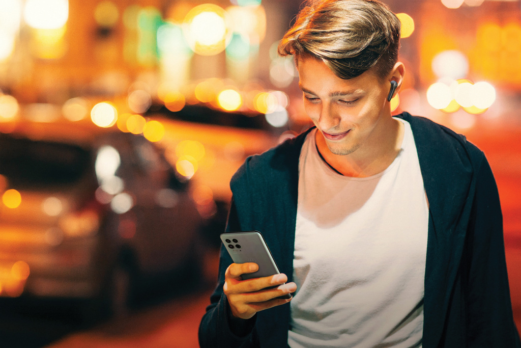 Handsome young man using smartphone in city